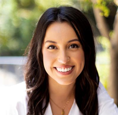 a woman's portrait in front of a greenery background